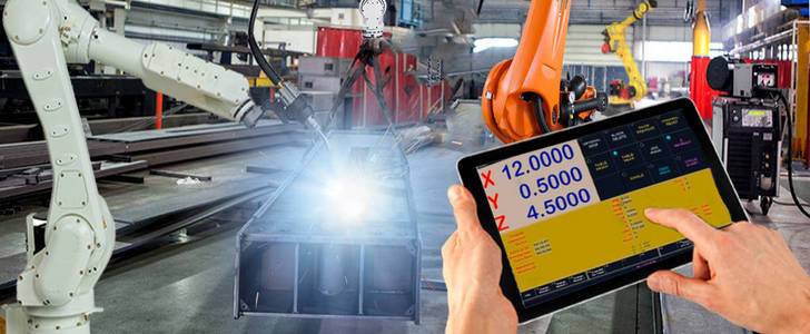 工程师用监控系统软件检查和控制智能工厂汽车工业中的焊接机器人自动